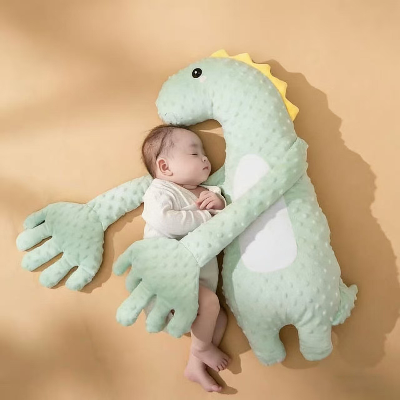Dinosaur doll baby holding and sleeping patting the bottom to soothe the dollgreen dinosaur baby soothing hand holding