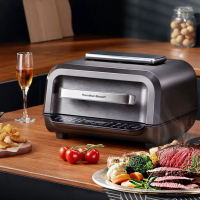Hamilton Beach AirGrill Air Fryer and Grill AF06201 with digital control panel sleek black design placed on wooden countertop with cooked steak vegetables and fries.